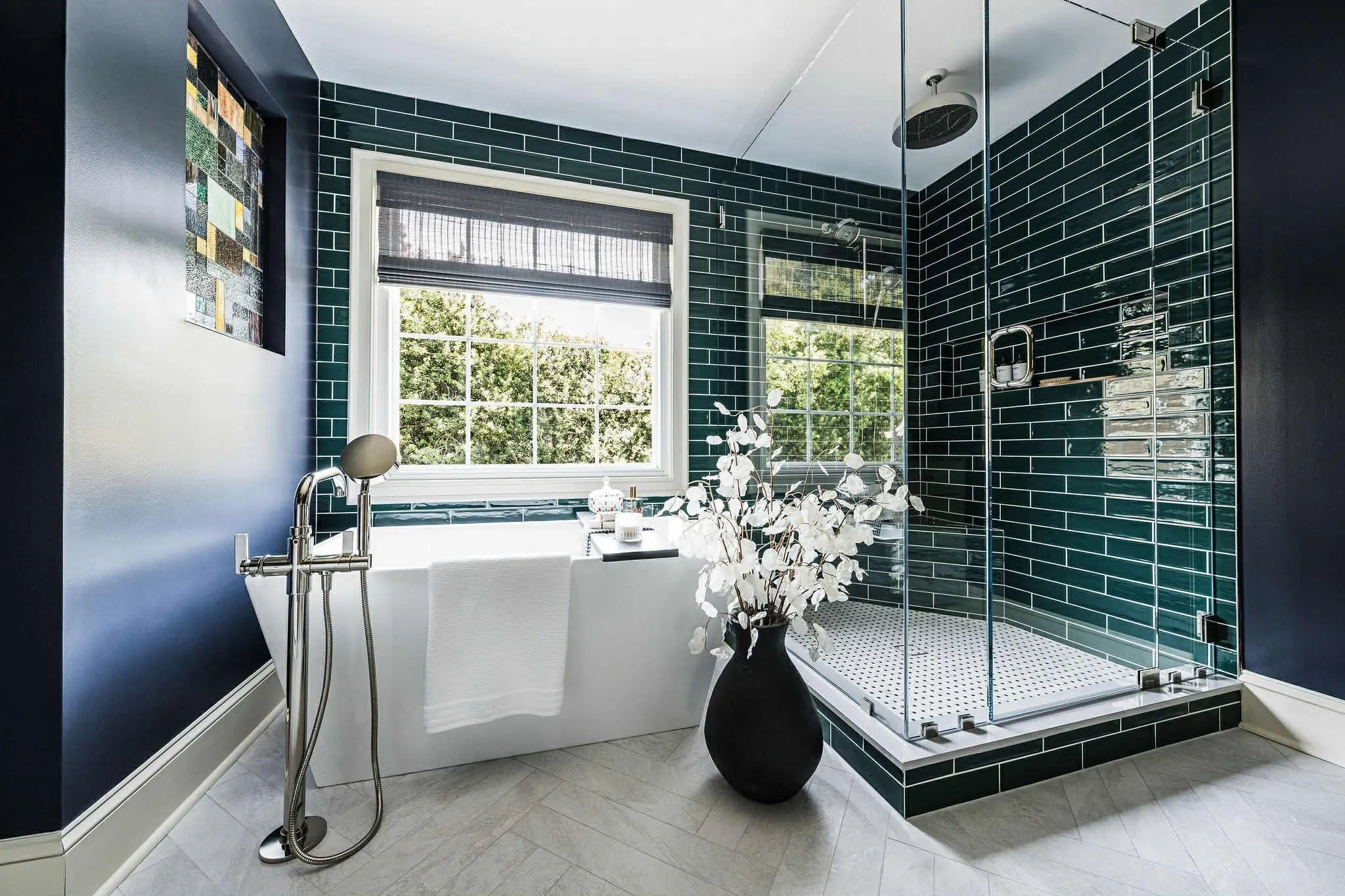 Renovated Cincinnati bathroom with a freestanding tub and dark green subway tile glass shower