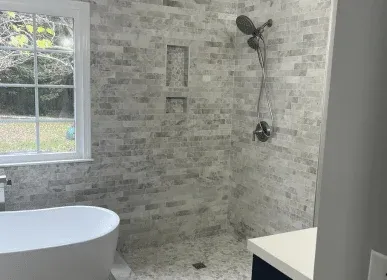 Tub-to-shower conversion with marble tile and freestanding tub