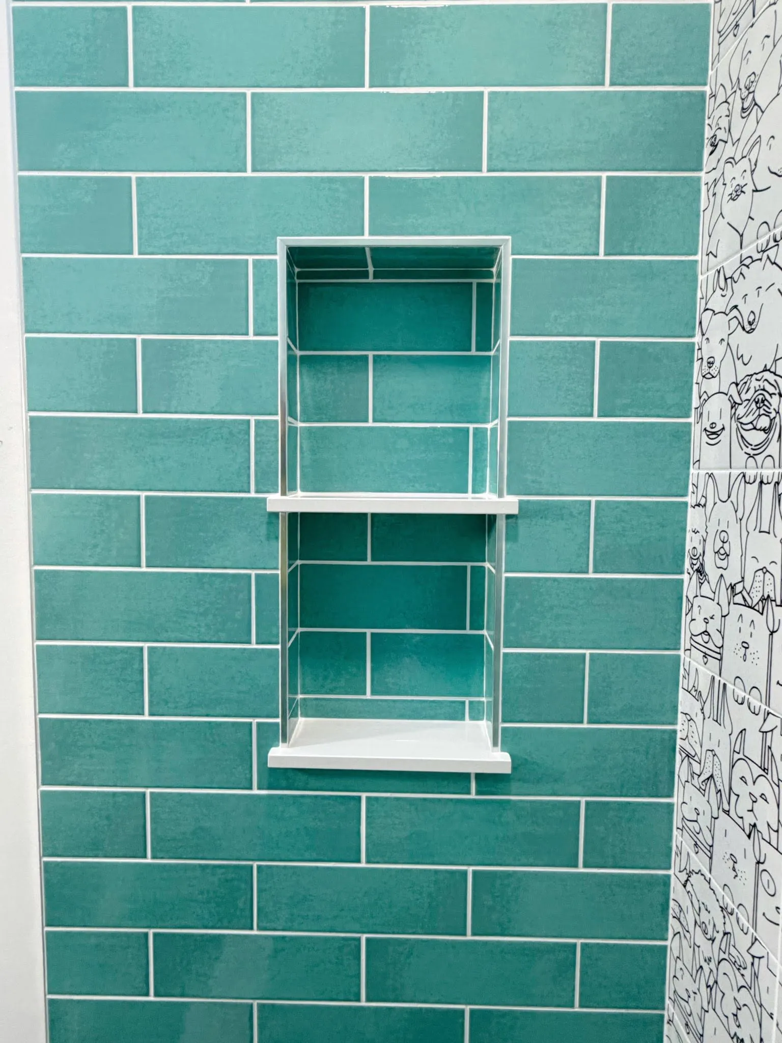 Professional teal subway tile installation with two precisely finished recessed shower niches