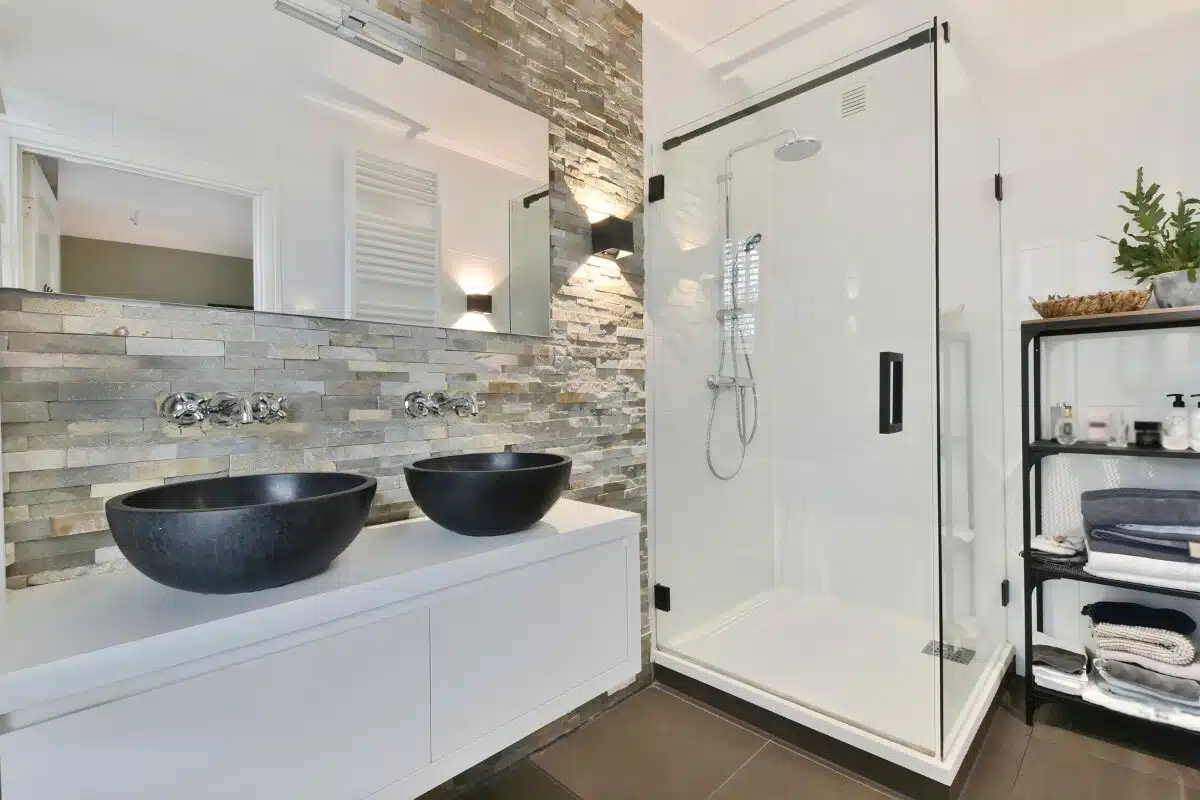 Bathroom remodel featuring a remodeled bathroom in Cincinnati, Ohio with a stone backsplash and large glass walk-in shower.