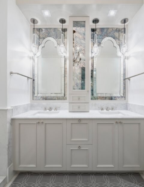 Bathroom remodel in Cincinnati, Ohio featuring an elegant dual vanity with marble tile on the wall.