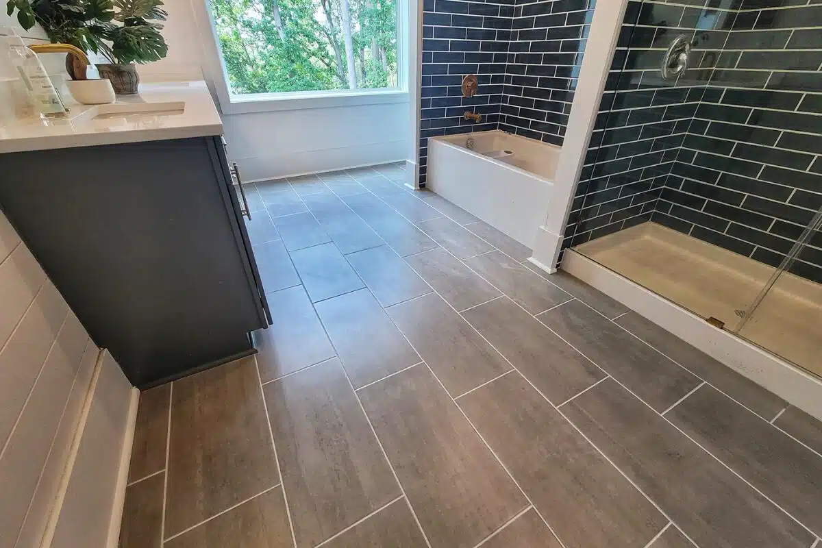 Bathroom remodel near me featuring a remodeled bathroom in Cincinnati with new tile floor and blue tile for the walk-in shower and tub surround.